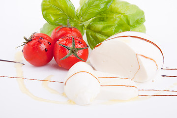 Image showing tasty tomatoe mozzarella salad with basil on white 