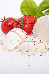 Image showing tasty tomatoe mozzarella salad with basil on white 