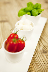 Image showing tasty tomatoes mazarella and basil on plate on table