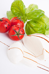 Image showing tasty tomatoe mozzarella salad with basil on white 