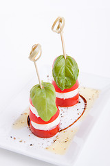 Image showing tasty tomatoe mozzarella salad with basil on white 