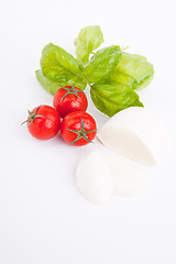 Image showing tasty tomatoe mozzarella salad with basil on white 
