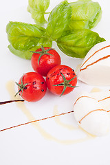 Image showing tasty tomatoe mozzarella salad with basil on white 