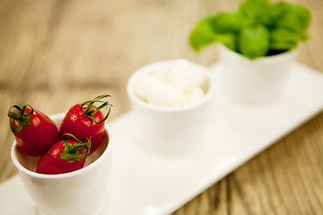 Image showing tasty tomatoes mazarella and basil on plate on table