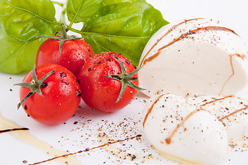 Image showing tasty tomatoe mozzarella salad with basil on white 