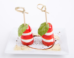 Image showing tasty tomatoe mozzarella salad with basil on white 