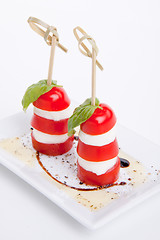 Image showing tasty tomatoe mozzarella salad with basil on white 