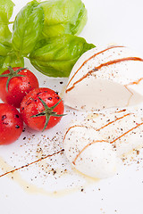 Image showing tasty tomatoe mozzarella salad with basil on white 