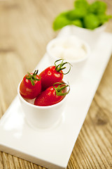 Image showing tasty tomatoes mazarella and basil on plate on table