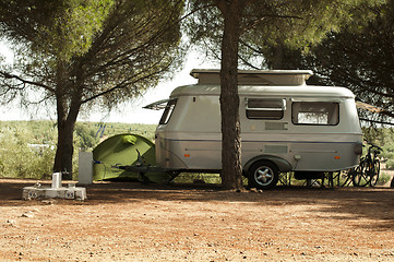 Image showing Small white caravan through the trees