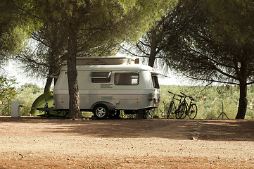 Image showing Small white caravan through the trees