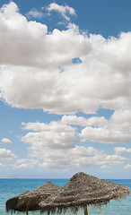 Image showing Large blue sky with clouds.Straw umbrellas