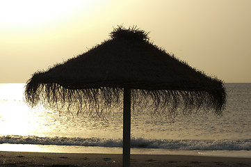 Image showing Straw umbrella on sunrize 