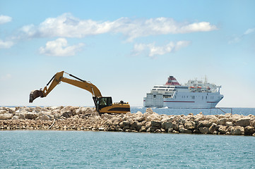 Image showing Building a dike. Excavator put stones