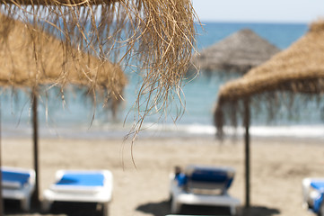 Image showing Straw beach umbrellas and sunbeds