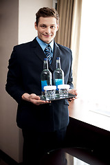 Image showing Male butler holding fresh beverages for customers