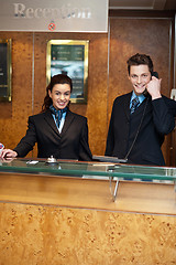Image showing Male and female at hotel reception busy working