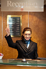 Image showing Beautiful female receptionist indicating upwards