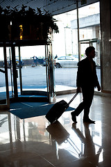 Image showing Man entering hotel lobby with his luggage