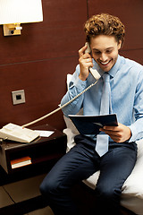 Image showing Smiling gentleman placing an order over the phone