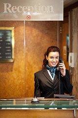 Image showing Attractive young receptionist receiving calls