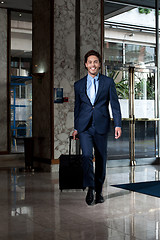 Image showing Business executive entering hotel lobby