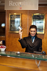 Image showing Beautiful receptionist posing with customers cash card