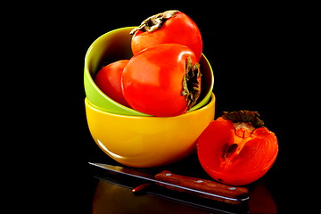 Image showing Juicy persimmon in a bowl and knife.