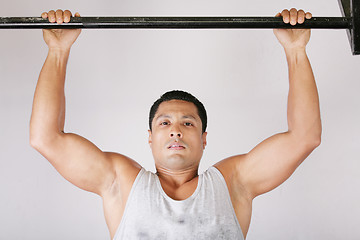 Image showing Athlete pull oneself up on gym background 