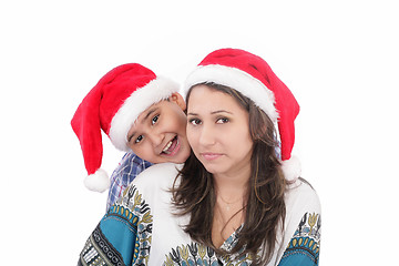 Image showing Cheerful boy and woman in Santa Claus hat. Isolated on white bac