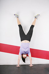 Image showing Brunette handstand woman isolated on gym