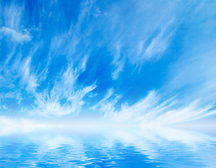 Image showing white fluffy clouds with rainbow in the blue sky