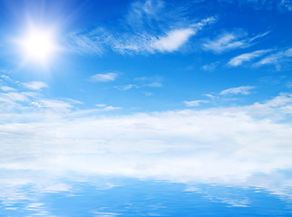 Image showing white fluffy clouds with rainbow in the blue sky