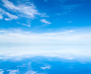 Image showing white fluffy clouds with rainbow in the blue sky