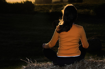 Image showing Seated on a hay bale