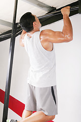 Image showing strong man performing pull ups in a bar 