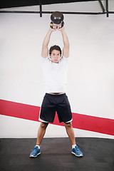 Image showing Young man doing kettlebell workout on gym