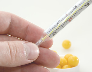 Image showing Hand with a thermometer 