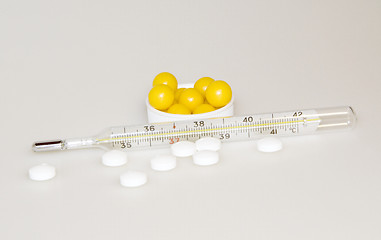 Image showing The thermometer, pills and vitamins 