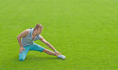 Image showing Young man exercising on sports field