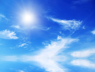 Image showing white fluffy clouds with rainbow in the blue sky