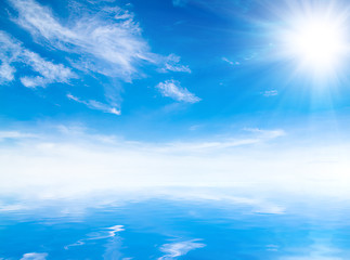 Image showing white fluffy clouds with rainbow in the blue sky