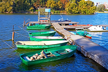 Image showing Boats and other craft are tied near the old pier