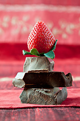 Image showing Strawberry Balancing on a Pile of Dark Chocolate