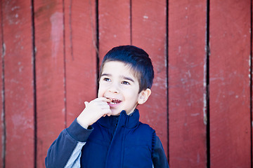 Image showing Happy Little Boy with a Finger in his Mouth