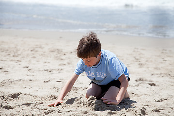 Image showing Little Boy Playing with sand on the Beach