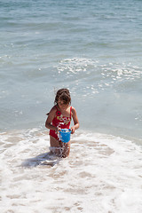 Image showing Little Girl Playing with a Bucket on the Beach
