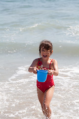 Image showing Little Girl Playing with a Bucket on the Beach