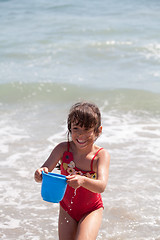 Image showing Little Girl Playing with a Bucket on the Beach