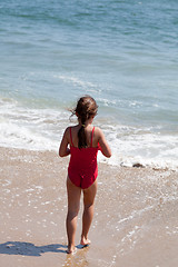 Image showing Little Girl Walking into the Ocean Surf on the Beach